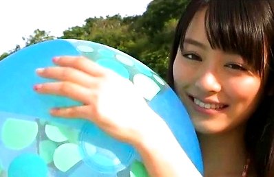 Rio Uchida Asian with naughty smile plays with big ball on beach